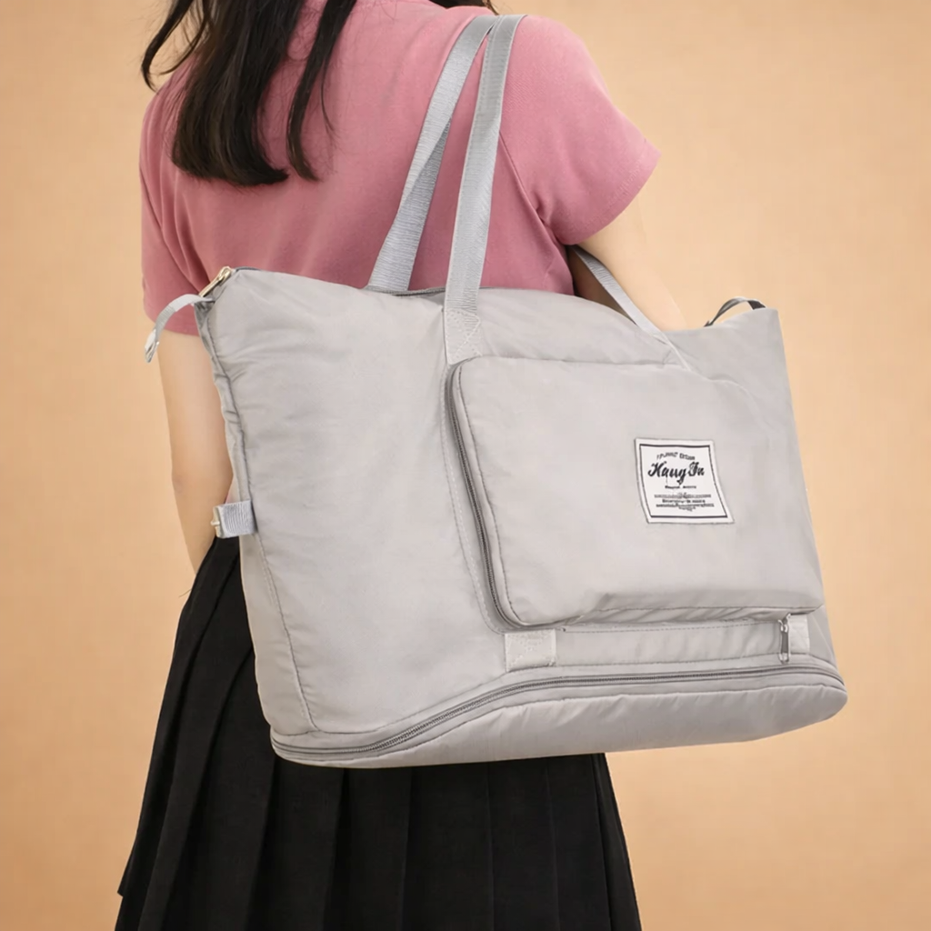 model-carrying-light-gray-nylon-travel-tote-bag-back-view-studio-fashion-shot.png