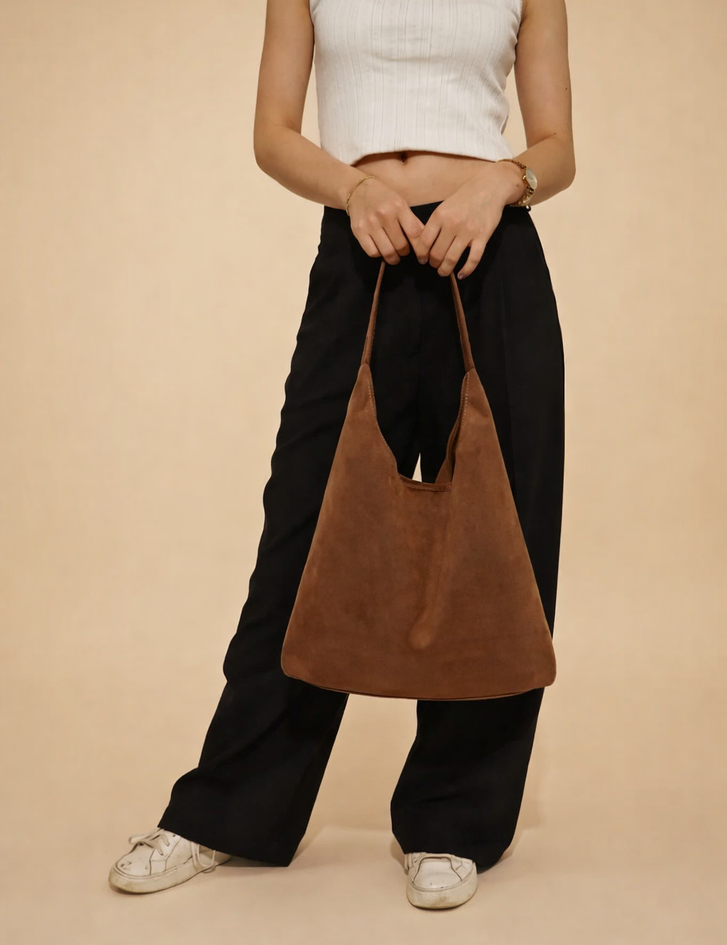 polish-female-model-holding-brown-suede-hobo-bag-european-studio-fashion-pose.png