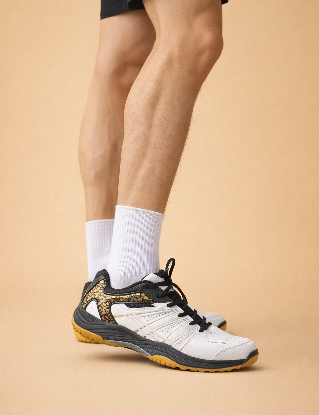 polish-male-model-wearing-white-black-gold-athletic-sneakers-studio-posed-shot-caramel-sand-background.png